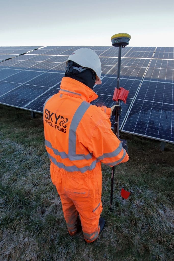 Sky Revolutions team member on solar farm conducting setting out services.